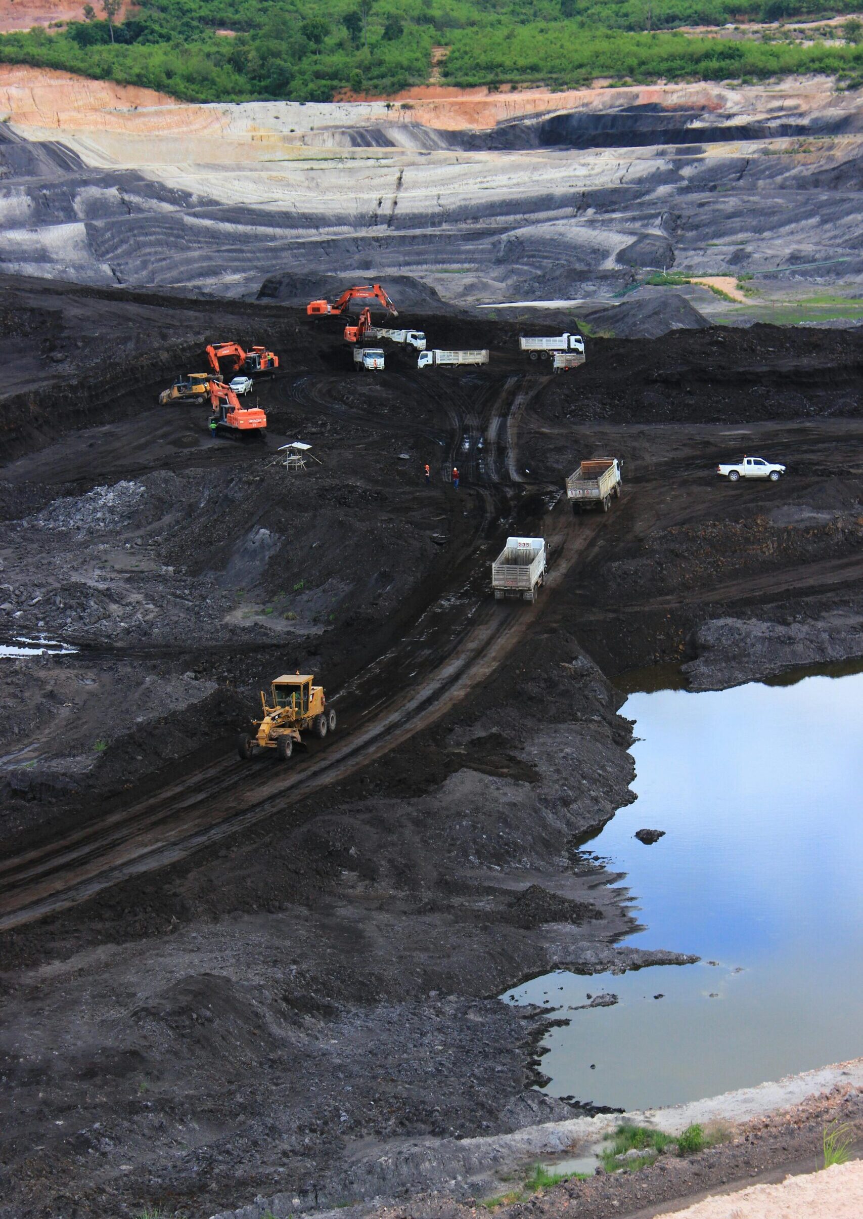 Aerial photograph showcasing machinery working in a vast open-pit mining site.